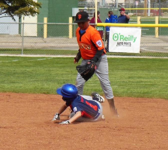 Photos by Brett Fisher. A Twins base runner slides safely into second against the Giants Saturday.