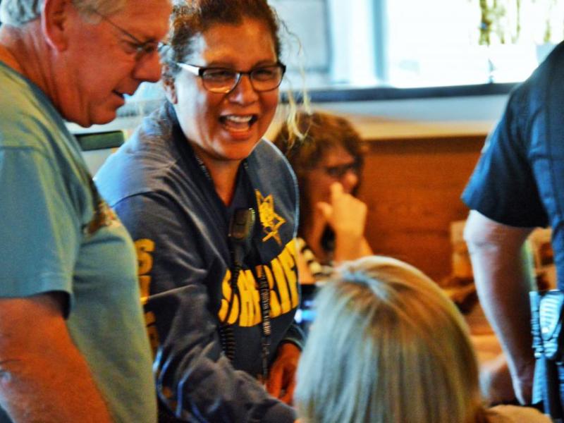 Photo by Brett Fisher. A DCSO deputy serves patrons at Chili's during a Tip-A-Cop event last summer.