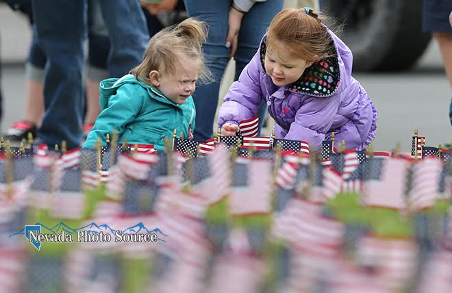 Photo by Cathleen Allison/Nevada Photo Source. Two girls place flags on the lawn at WNC.