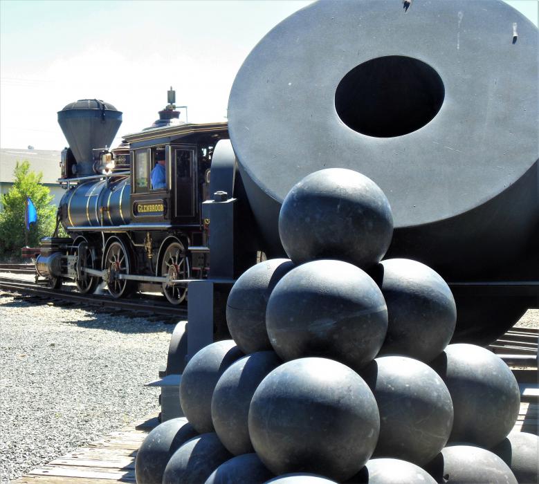 A mortar and canisters in the foreground of The Glennbrook engine at the NSRM.