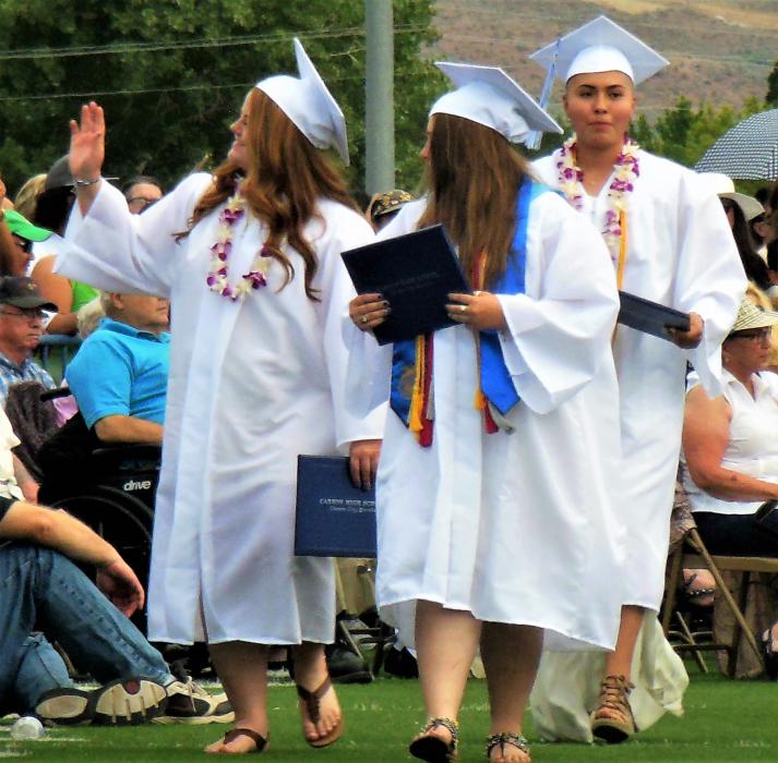 A graduate acknowledges her family in the crowd Saturday upon receiving her diploma.