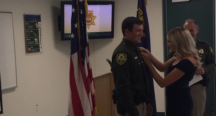 CCSO's newest deputy Dylan Etchegaray places the sworn officer pin on him during Friday's ceremony.