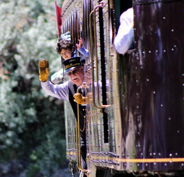 Photos by Brett Fisher. The conductor waves as the McKeen Car crosses the road at the NSRM.