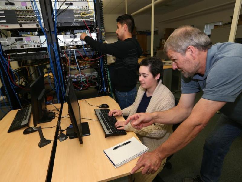 CIT instructor Dave Riske works with Sergio Teutli, rear, and Chrissa Johnson at the WNC Carson City campus.