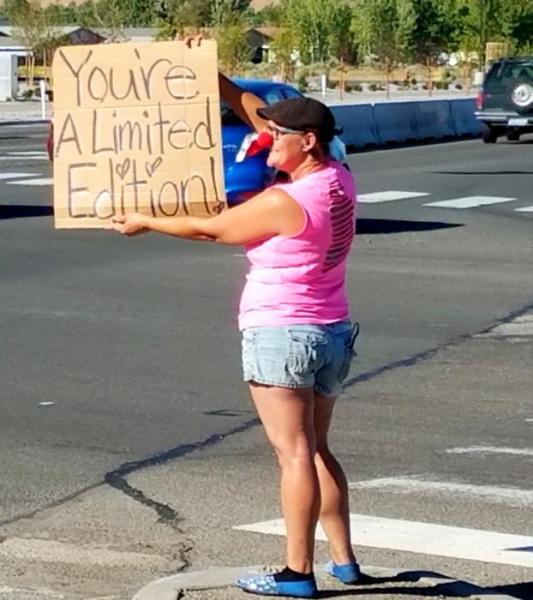 Photo by Brett Fisher. E.D. Crouser cheers up commuters Wednesday afternoon.