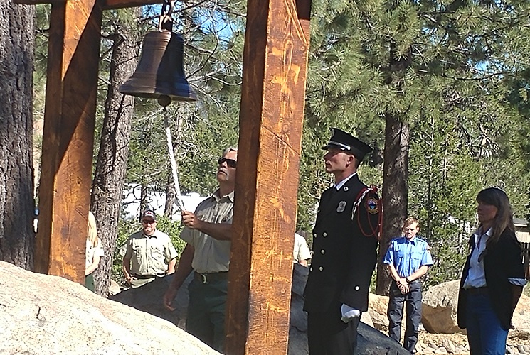 Kit Bailey rings the new bell outside Lake Valley Fire Department.