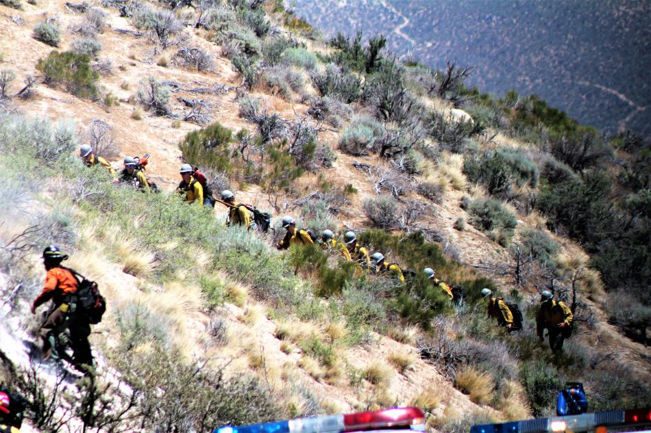 A line of firefighters near Spooner Highway 50 knocked down the acre-fire Tuesday afternoon. Photo by Brett Fisher
