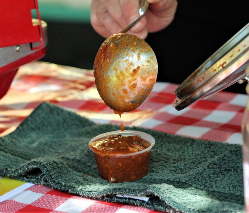 Chili from Chili the Kid drips from a ladel into the serving cup Saturday.