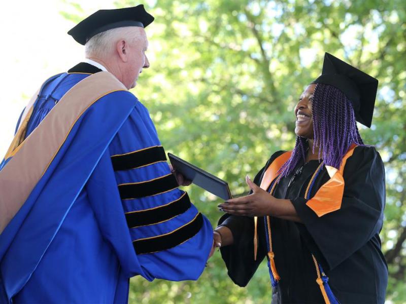 President Chet Burton congratulates Cassandra Luster at the Western Nevada College 2017 Commencement.