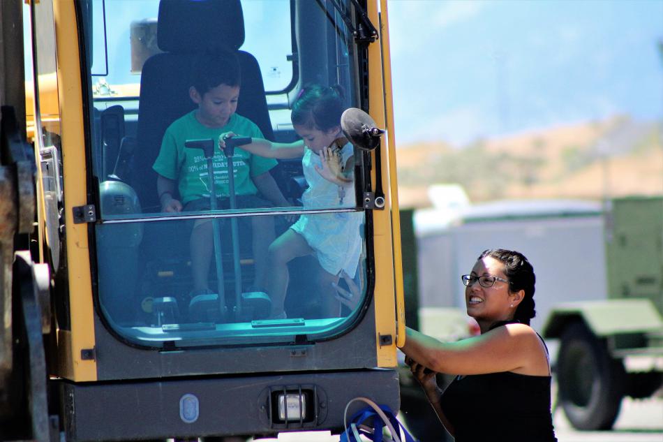A brother and sister inside the cab of a road grader Saturday.