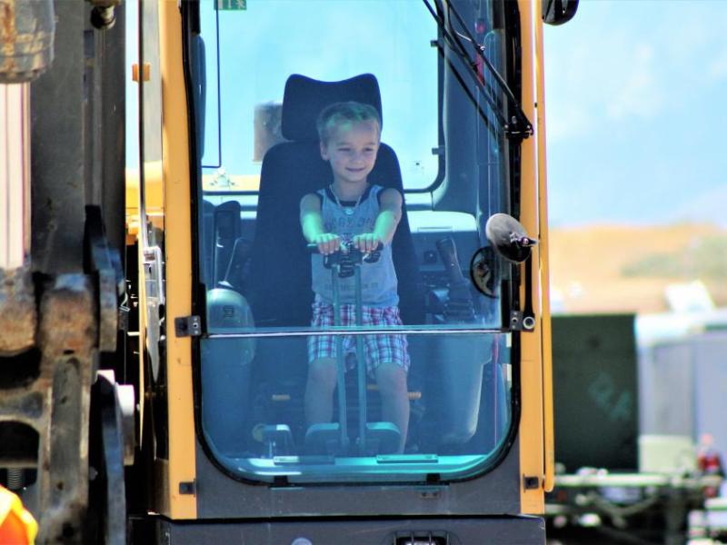 A young boy peers out the windshield from the cockpit of a heavy tractor Saturday.
