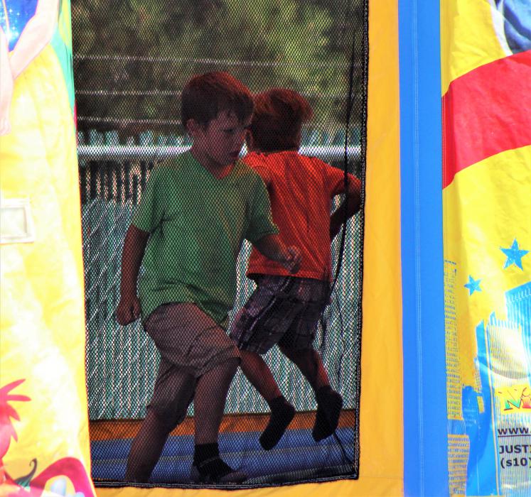 Two boys play in a bounce house at the Carson City corporate yard Saturday.