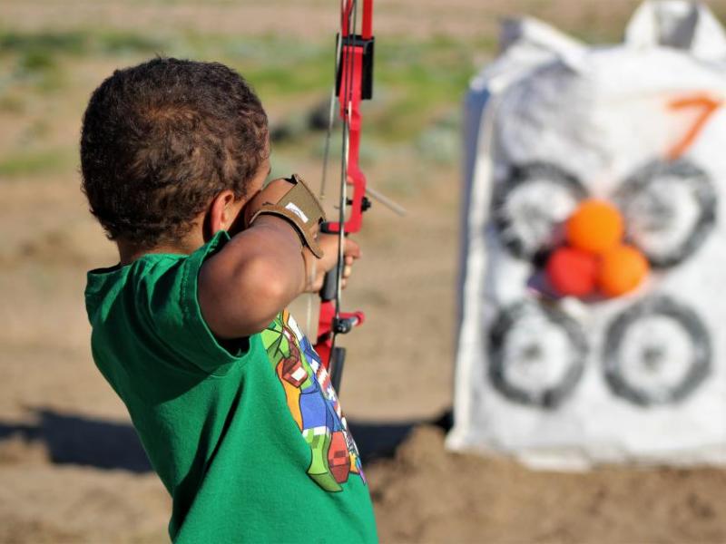 Photos by Brett Fisher. Skylar Easley, 7, of Reno shoots at a balloon target using a compound bow.