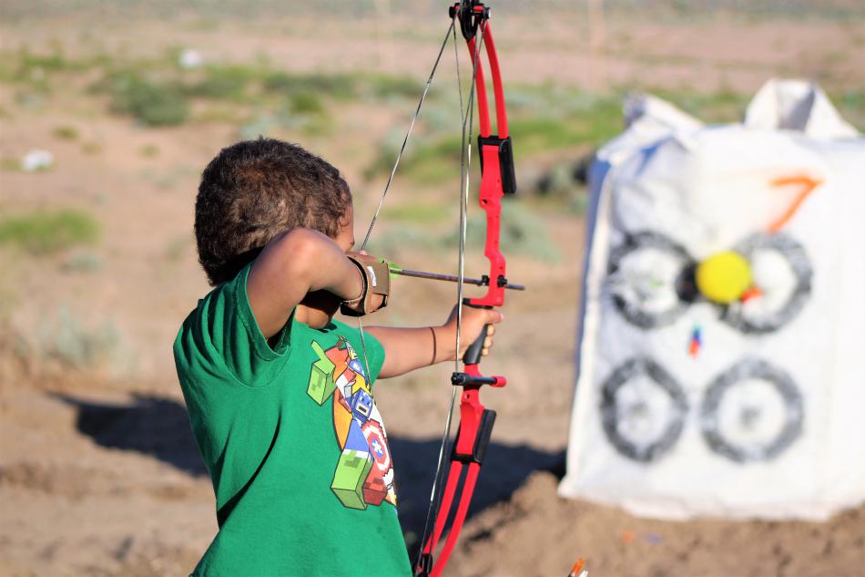 A youth shoots at balloon targets on the practice range.