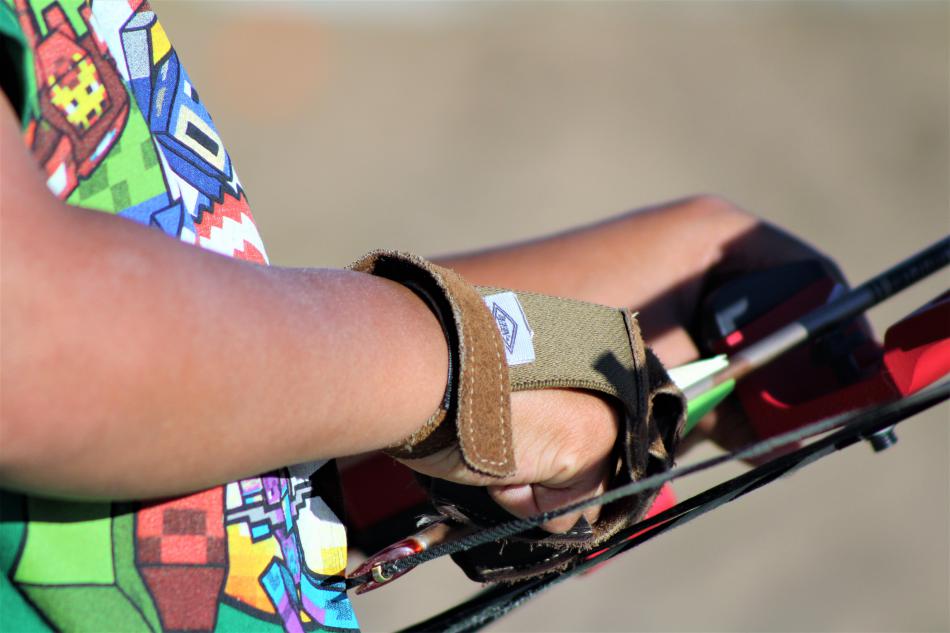 A youth loads an arrow in his compound bow.