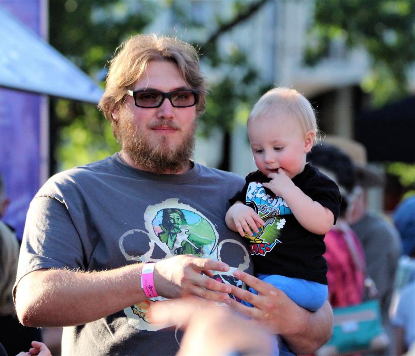 A father holds his son Saturday along Curry Street.