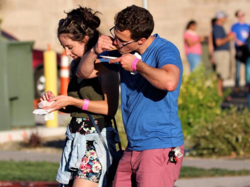 Photos by Brett Fisher. A young couple indulges in a homemade taco Saturday evening along Curry Street.
