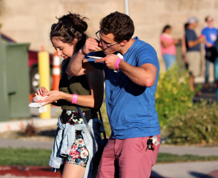 Photos by Brett Fisher. A young couple indulges in a homemade taco Saturday evening along Curry Street.
