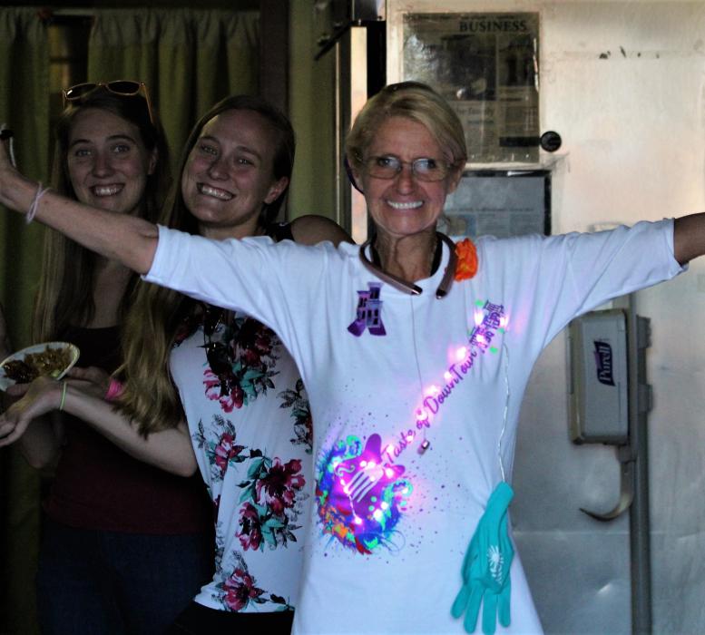 A woman wears a light up Taste of Downtown shirt inside Yang's Kitchen.