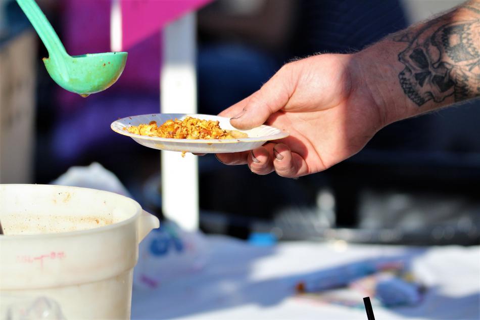 Hot sauce is poured over tamale filling at the Lady Tamales.