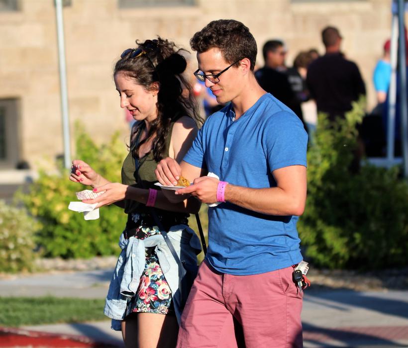 A young couple enjoys their evening, strolling down Curry Street.