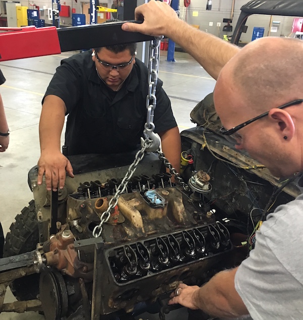 Randy Weaver and David Monroy remove the engine from a 1952 Willys Jeep.