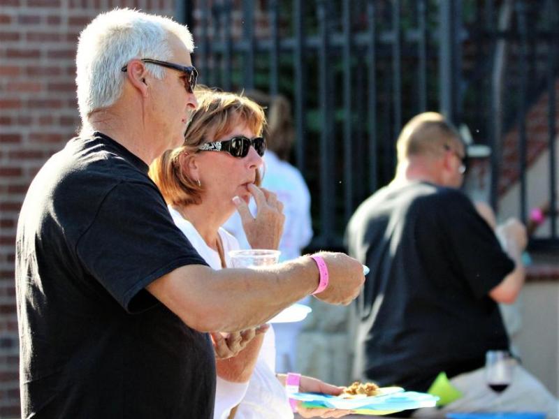 Photo by Brett Fisher. A couple tastes the goods from Flat Earth Pizza last Saturday during the 2017 Taste of Downtown.