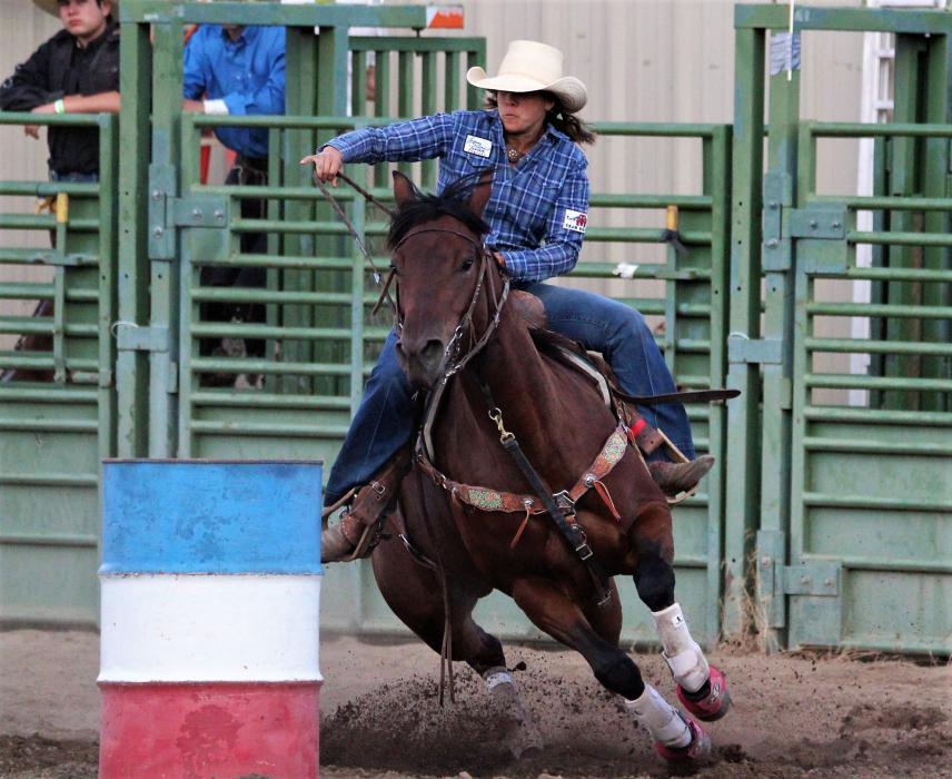A barrel racer cuts tightly around a barrel Friday.
