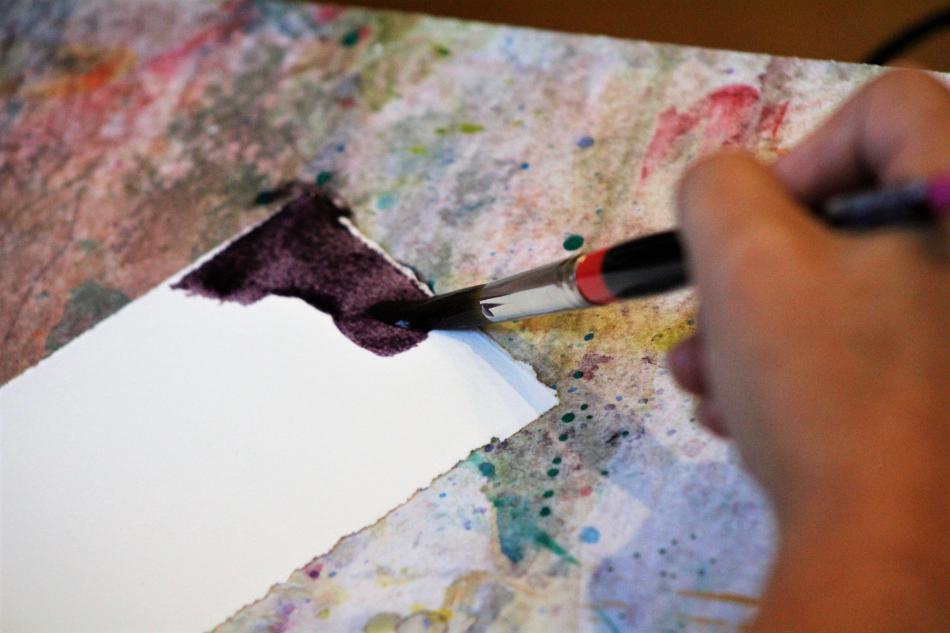 Water color paint is applied to paper inside the Artsy Fartsy Creative Center.