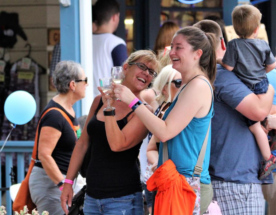 Photos by Brett Fisher. Wine walkers toast their glasses in Telegraph Square Saturday.