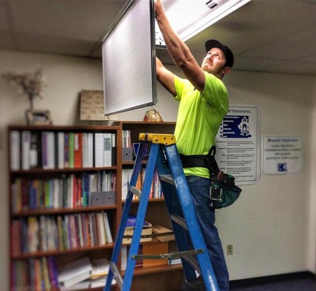 Photo courtesy Dan Davis. A CCSD maintenance worker installs LED lighting.
