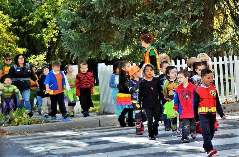 Photo by Brett Fisher. Trick-or-treaters cross West Robinson Street on their way to the Governor's Mansion last Halloween.