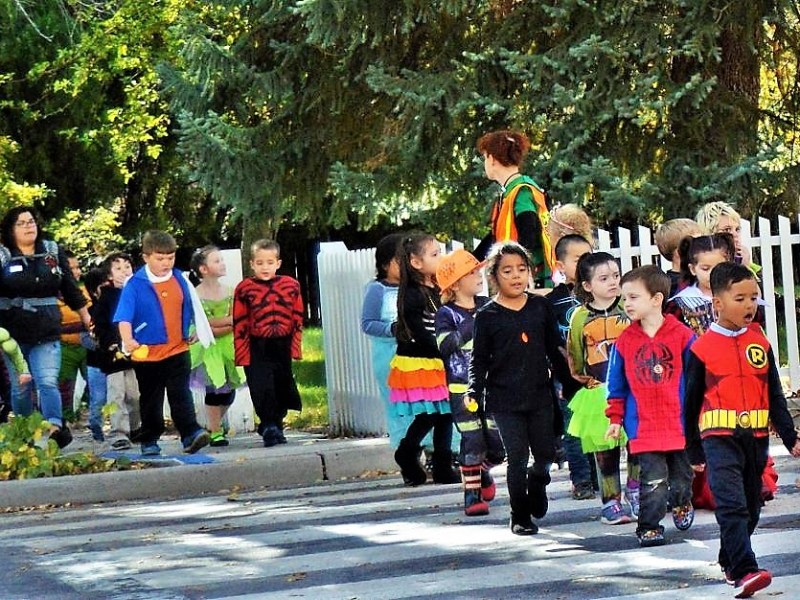 Photo by Brett Fisher. Trick-or-treaters cross West Robinson Street on their way to the Governor's Mansion last Halloween.