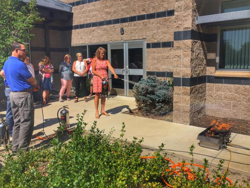 Empire Elementary School Principal Susan Squires demonstrates how to put out a fire using an extinguisher.