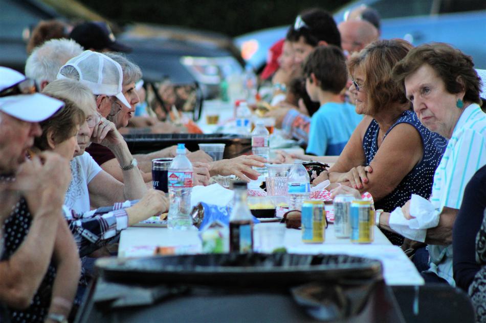 Diners socialize and eat at the community table set up for Wheeled Food Wednesdays.
