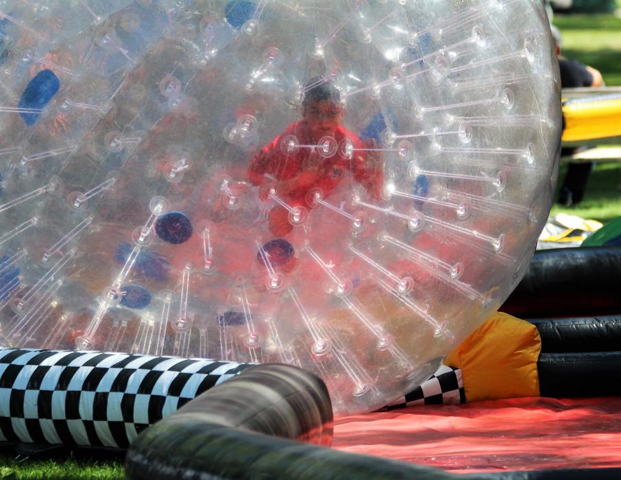 A boy maneuvers in a hamster ball Saturday in Mills Park.