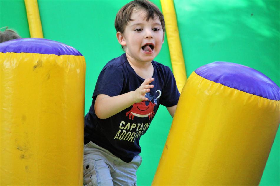A boy bounces up after sliding to the bottom of an inflatable slide Saturday in Mills Park.