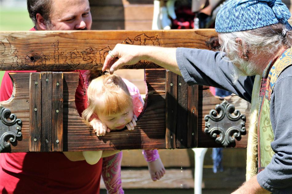 An unhappy toddler receives ritual water sprinkles from Captain Krakken of the Pirates of Reno Saturday.