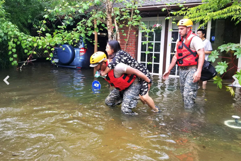 A Texas National Guardsman carries a resident from her home. Army National Guard photo by Lt. Zachary West