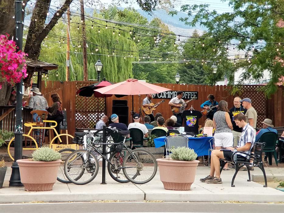Bicycles parked in front of the Comma Coffee Courtyard as visitors listen to live music.