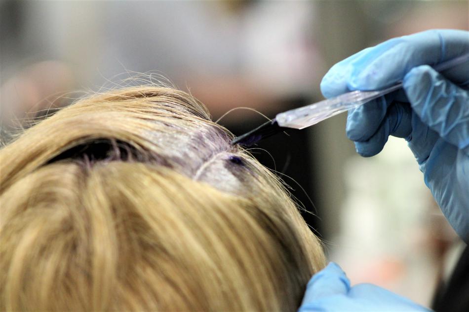 Coloring is applied to the roots of a client's hair Thursday.
