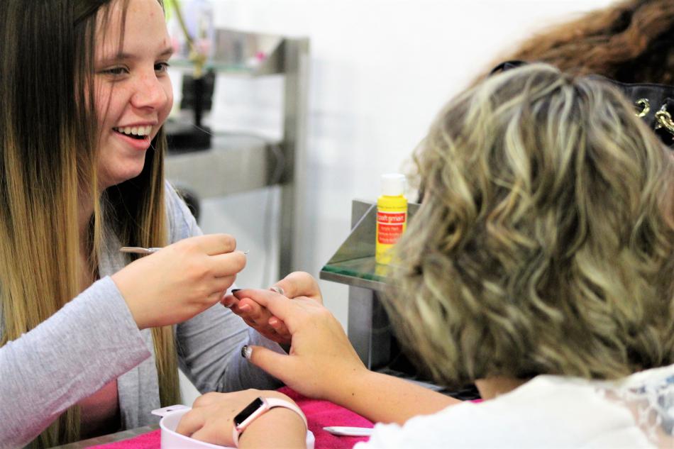 A nail technician talks with her client Thursday.