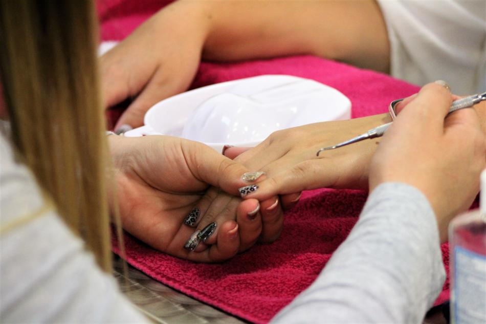 A nail technician puts the finishing touches on a client's nails.