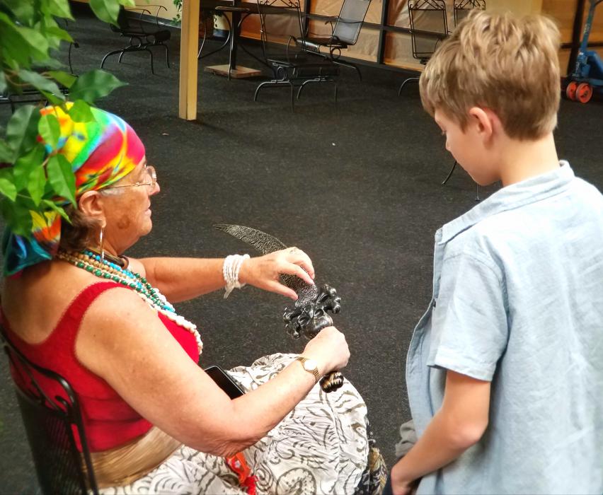 A lady pirate gives a visitor a sword lesson.