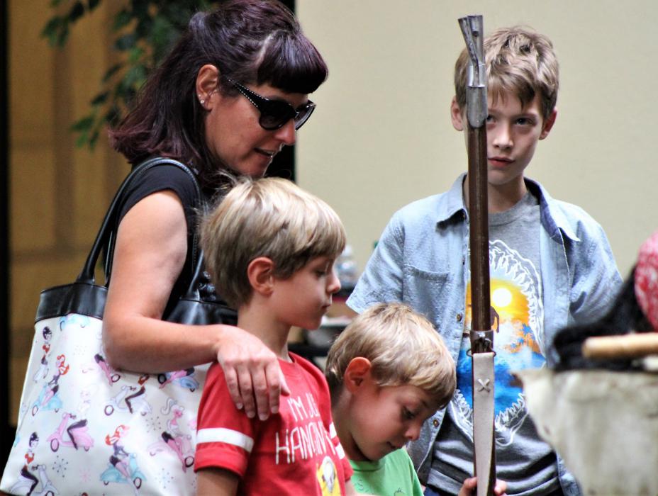 Boys check out a black powder musket displayed at the pirate encampment.