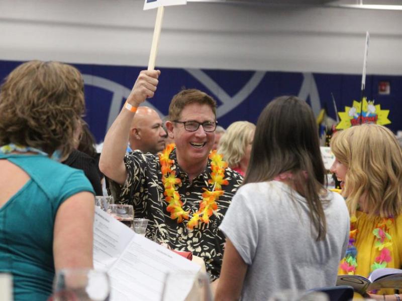 Bill Calhoun raises a paddle during the live auction, one of the most popular and enduring events at the luau.