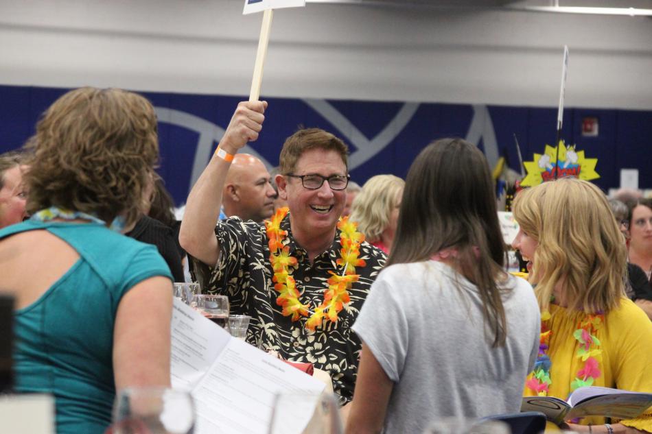 Bill Calhoun raises a paddle during the live auction, one of the most popular and enduring events at the luau.