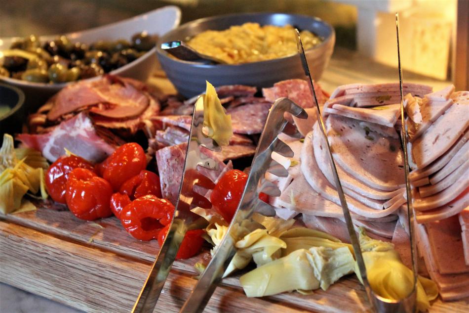 A plate of meats, cheeses and vegetables.