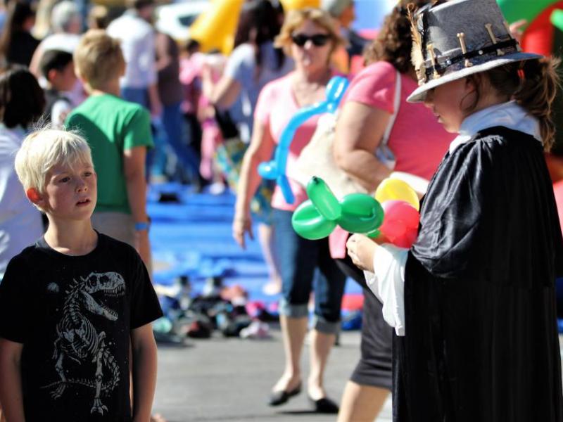 Photos by Brett Fisher. A boy watches a balloon artist at work Friday.