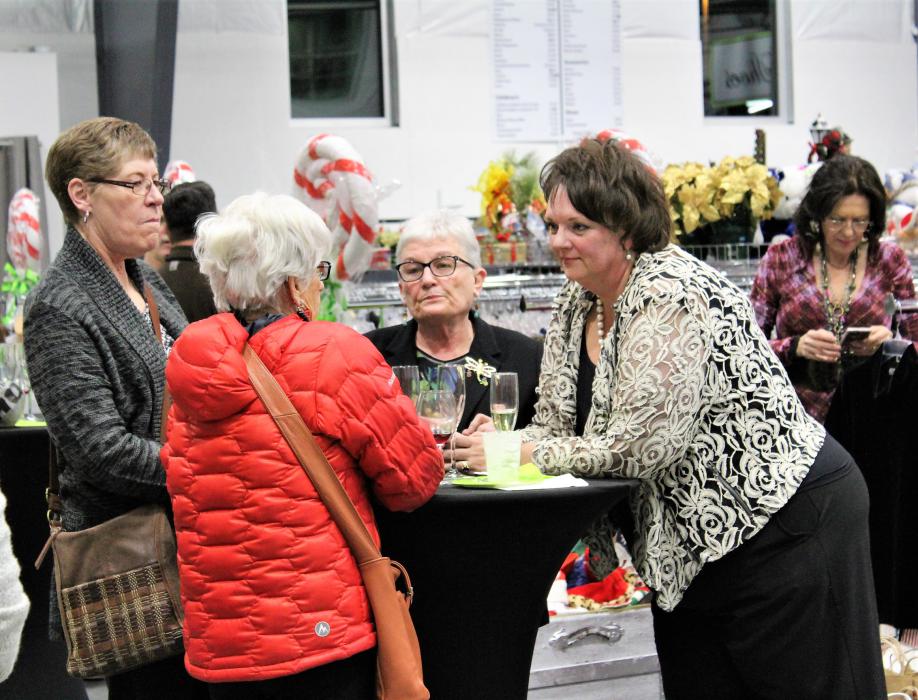Lisa Lee (right) talks with guests Thursday night at the Classy Seconds grand opening celebration.